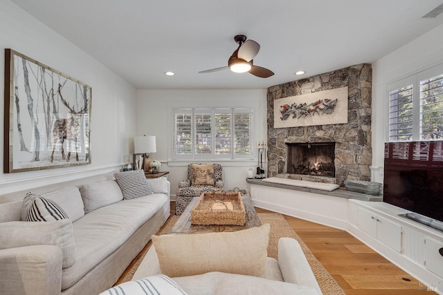 living area featuring a fireplace, recessed lighting, visible vents, light wood-style floors, and a ceiling fan