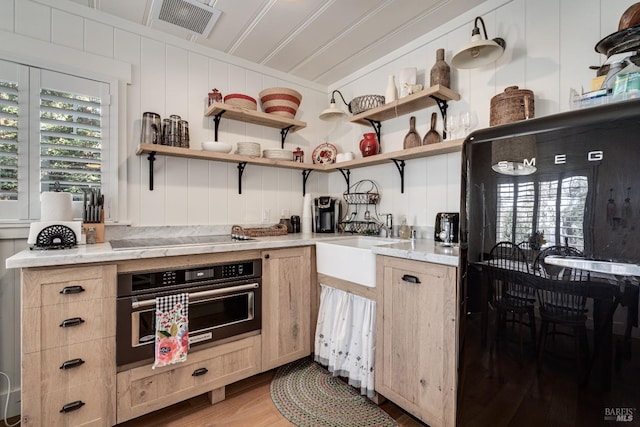 kitchen with wall oven, light brown cabinets, black electric cooktop, and open shelves