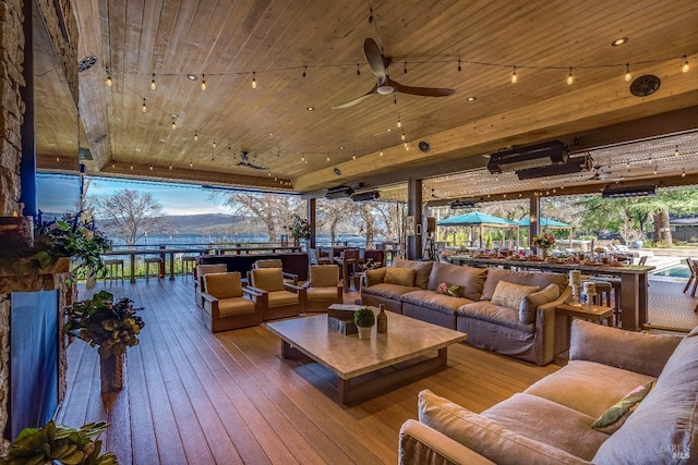 wooden terrace with a ceiling fan and an outdoor hangout area