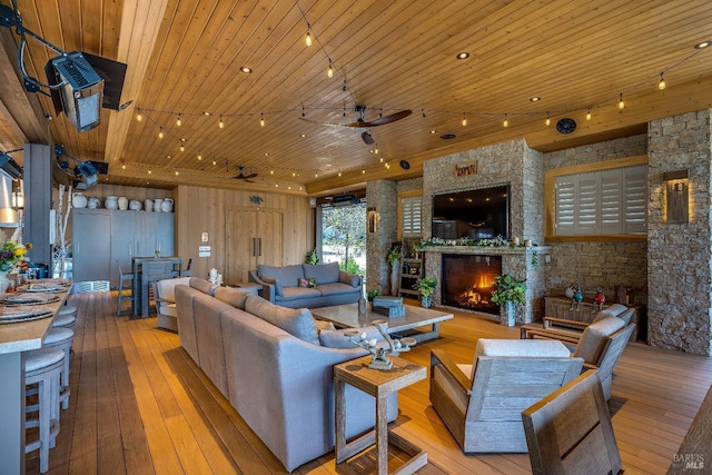 living area featuring ceiling fan, wooden ceiling, a fireplace, and hardwood / wood-style flooring