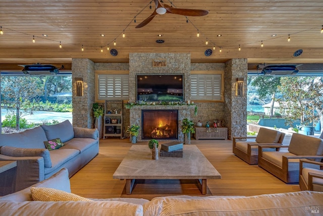 living area featuring wooden ceiling, an outdoor stone fireplace, and hardwood / wood-style floors