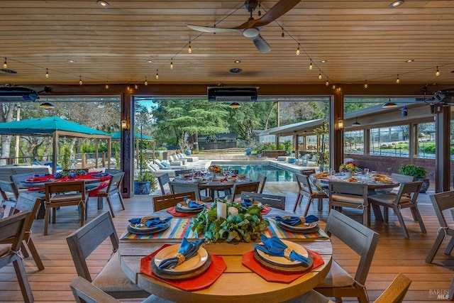 sunroom / solarium featuring a ceiling fan and wood ceiling