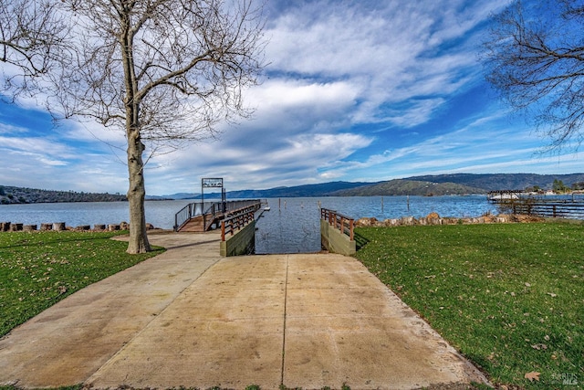 dock area with a lawn and a water view