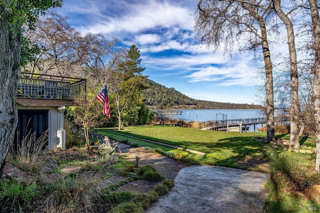 view of yard with a water view and a boat dock