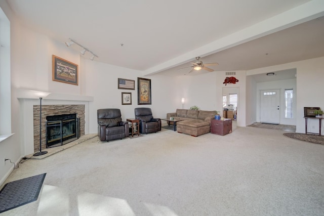 living room with rail lighting, carpet floors, beam ceiling, a fireplace, and ceiling fan