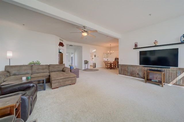 living room featuring ceiling fan with notable chandelier, carpet floors, and beam ceiling