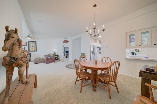carpeted dining area with a chandelier
