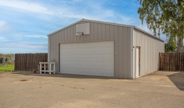 detached garage featuring fence