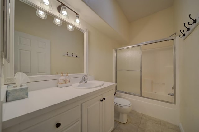 bathroom with toilet, tile patterned flooring, bath / shower combo with glass door, and vanity