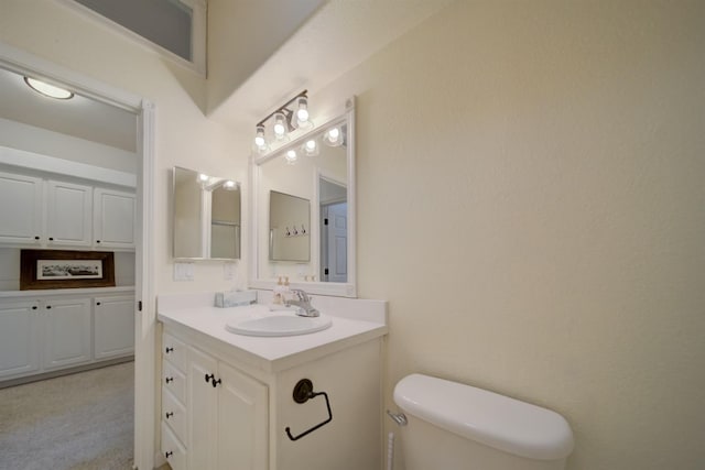 half bathroom with vanity and toilet