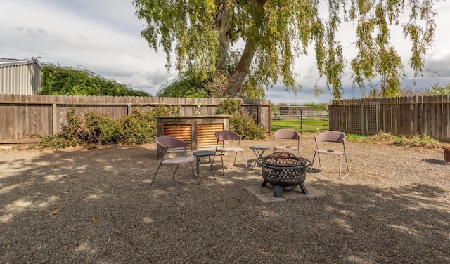 view of yard with a fenced backyard and a fire pit