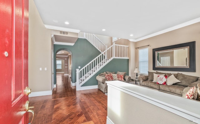 entrance foyer featuring arched walkways, visible vents, stairway, wood finished floors, and baseboards