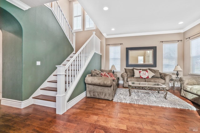 living room with a wealth of natural light, wood-type flooring, and crown molding
