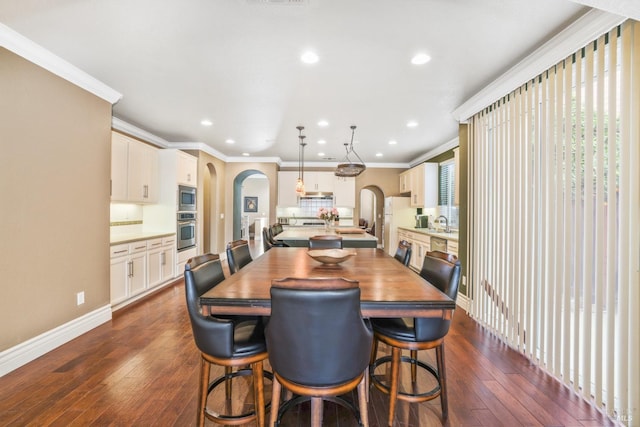 dining area featuring ornamental molding, arched walkways, and dark wood finished floors