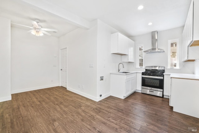 kitchen with dark wood-style floors, wall chimney range hood, a sink, and gas range