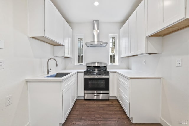 kitchen featuring a sink, wall chimney range hood, stainless steel range with gas cooktop, and white cabinets