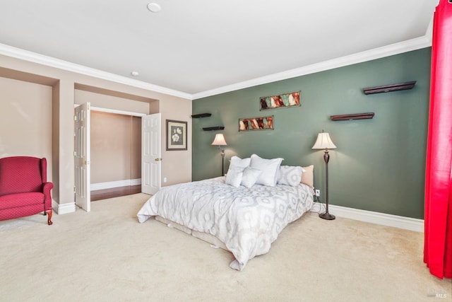 carpeted bedroom with ornamental molding and baseboards