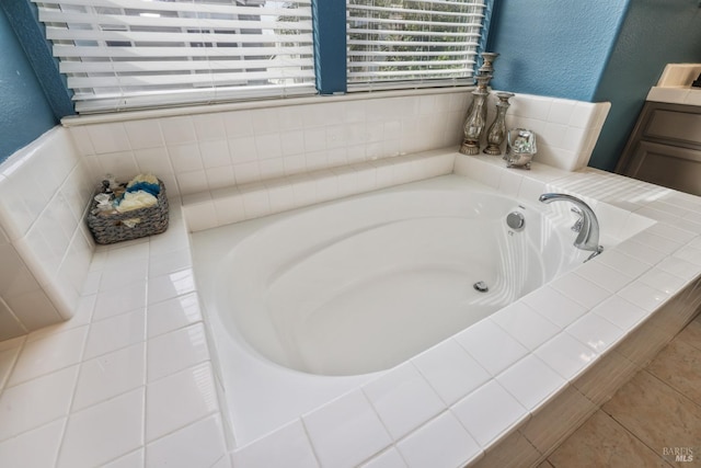 full bath with a textured wall, a garden tub, and tile patterned floors