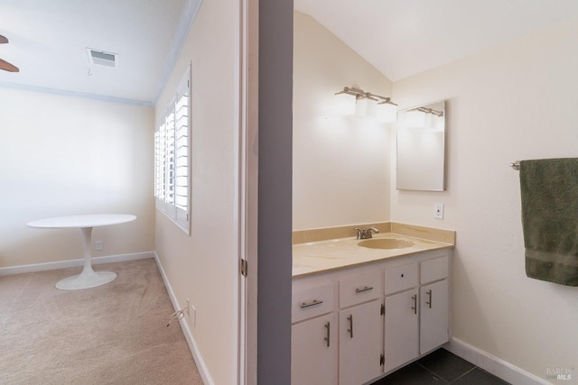 bathroom featuring vanity, visible vents, vaulted ceiling, baseboards, and crown molding