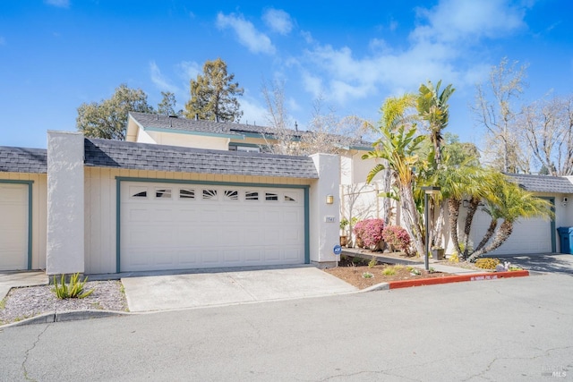 view of front of house with a shingled roof, concrete driveway, and an attached garage