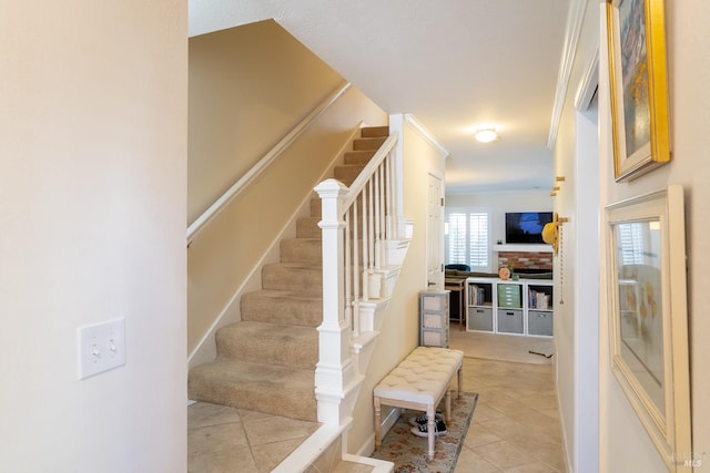 staircase featuring ornamental molding and tile patterned flooring