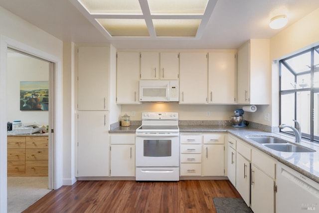 kitchen featuring white appliances, dark wood-type flooring, and a sink