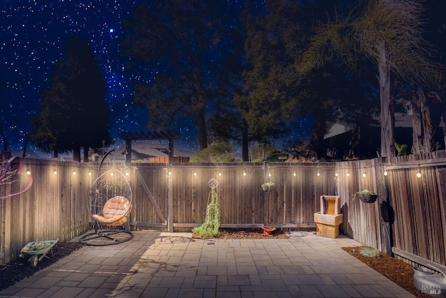 patio at night with a fenced backyard