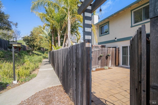 exterior space featuring a patio, fence, and stucco siding