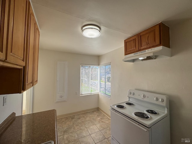 kitchen with white range with electric stovetop, baseboards, dark countertops, brown cabinets, and under cabinet range hood