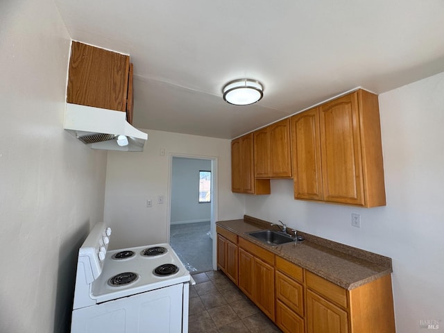 kitchen featuring under cabinet range hood, a sink, brown cabinetry, dark countertops, and white electric range oven