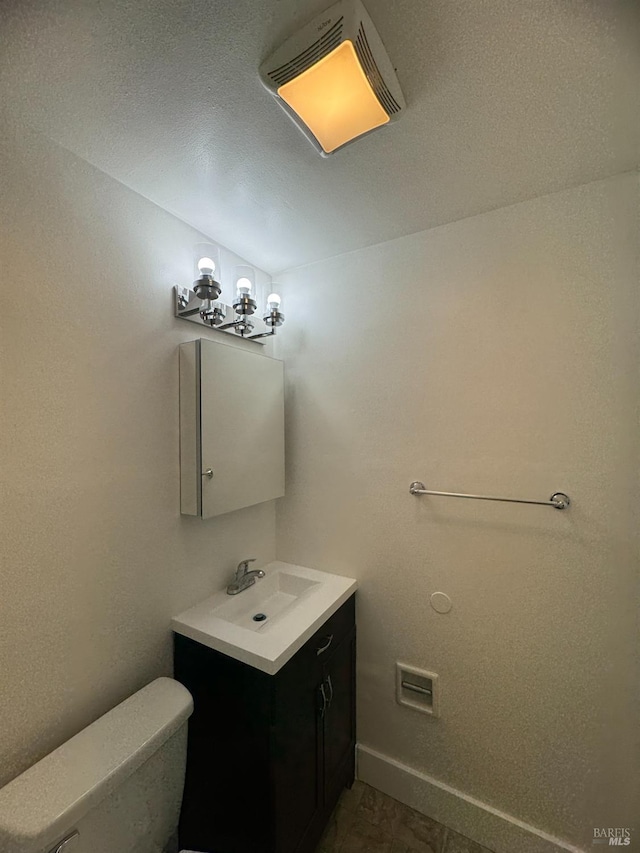 half bathroom with baseboards, visible vents, vanity, and toilet