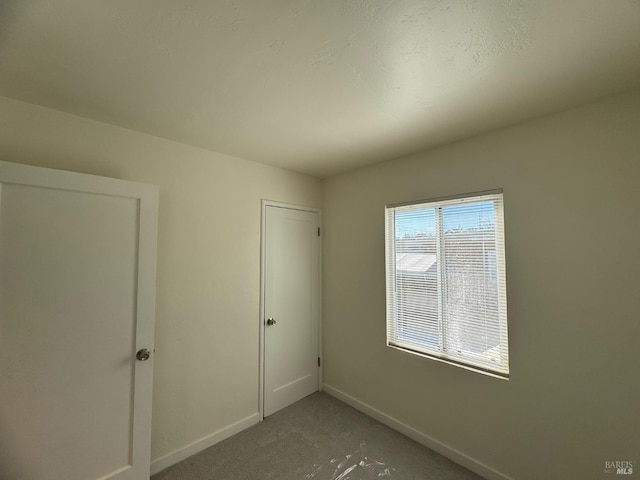 unfurnished bedroom featuring light colored carpet and baseboards