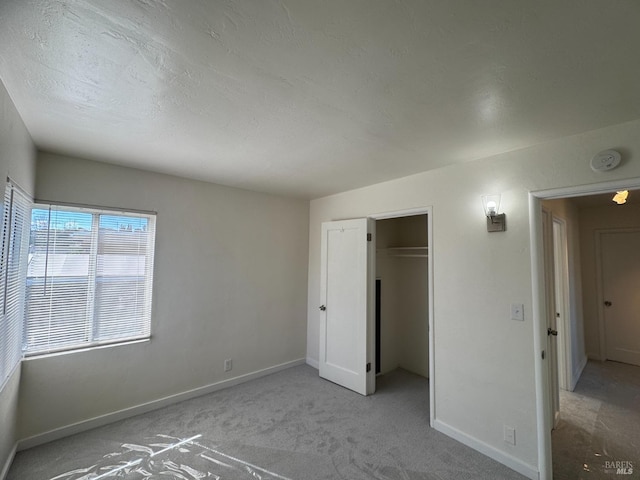 unfurnished bedroom featuring a closet, baseboards, and carpet flooring