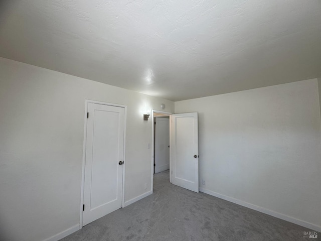 unfurnished bedroom with carpet floors and baseboards