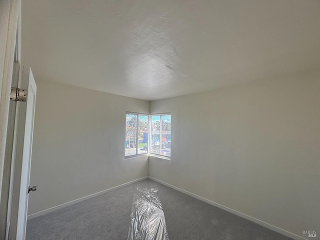 carpeted empty room with baseboards