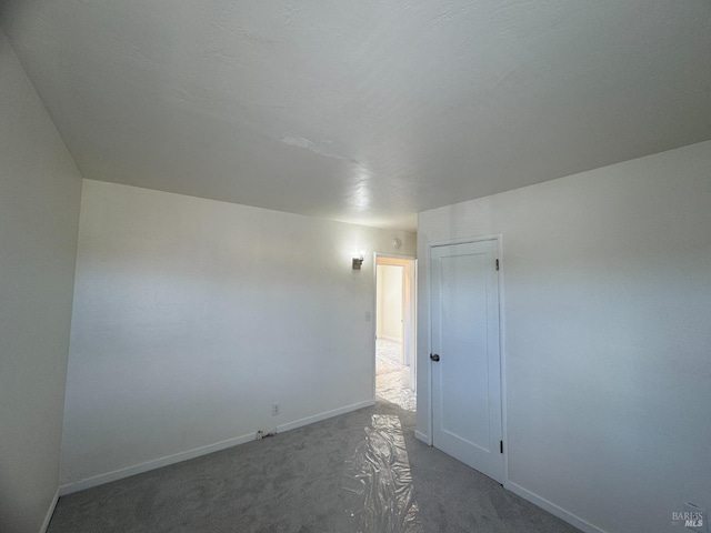 carpeted empty room with baseboards