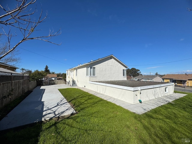 view of property exterior with a fenced backyard, a yard, and stucco siding