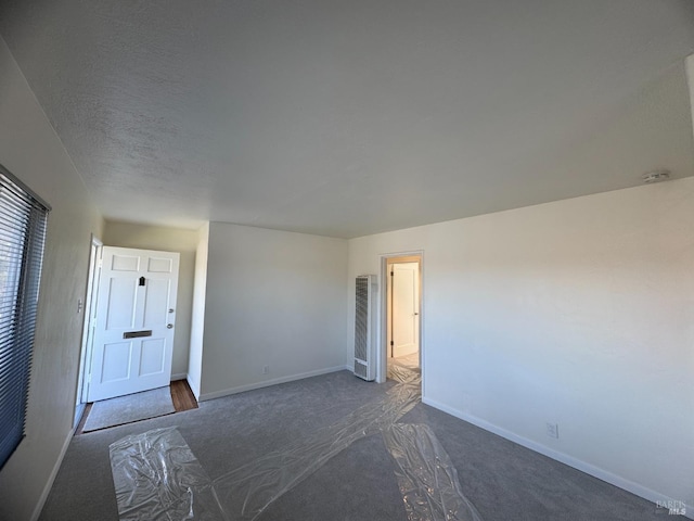 spare room featuring a textured ceiling and baseboards