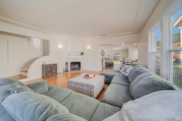 living room with a fireplace, plenty of natural light, and stairs