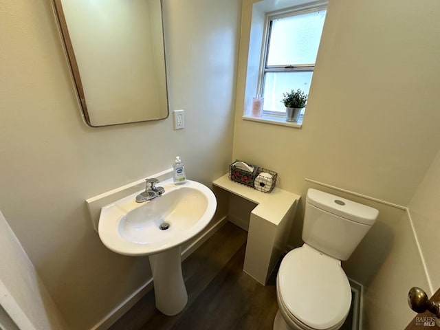 half bath with wood finished floors and toilet