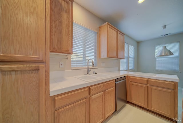 kitchen featuring tile counters, visible vents, a peninsula, stainless steel dishwasher, and a sink