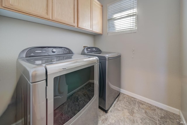 laundry room featuring cabinet space, washer and clothes dryer, and baseboards