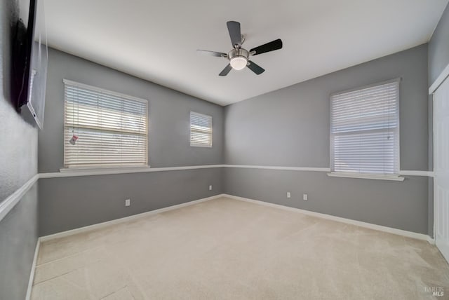 unfurnished room featuring carpet floors, baseboards, and a ceiling fan