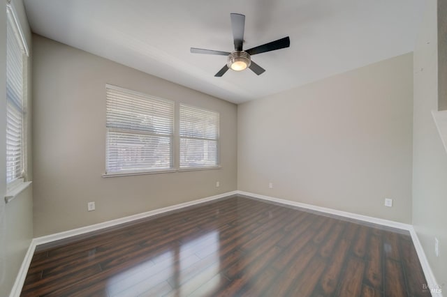 spare room featuring dark wood-type flooring, baseboards, and a ceiling fan