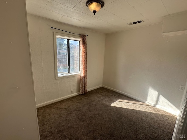 spare room with carpet, visible vents, and baseboards