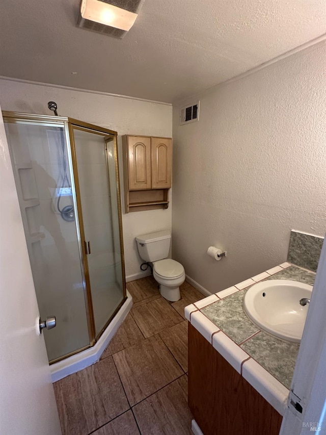 full bath featuring visible vents, a textured wall, a shower stall, and toilet