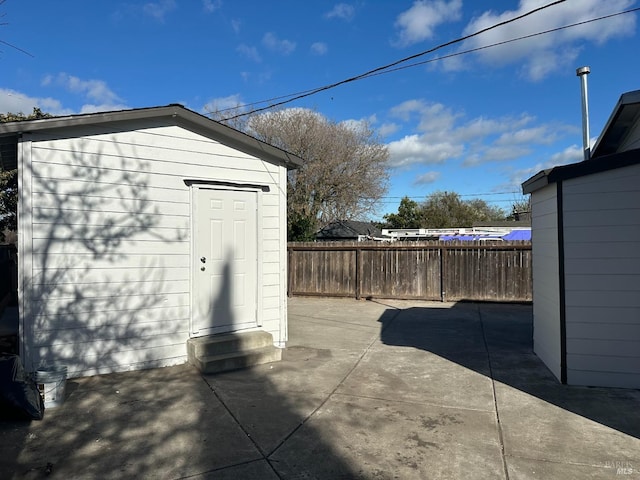 view of outdoor structure featuring fence and an outdoor structure