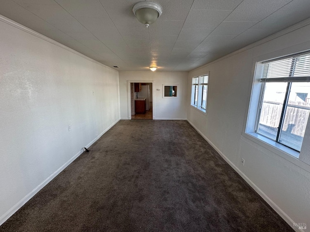 spare room with carpet and baseboards