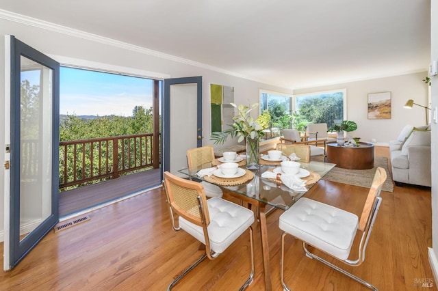 dining space featuring crown molding, visible vents, and wood finished floors