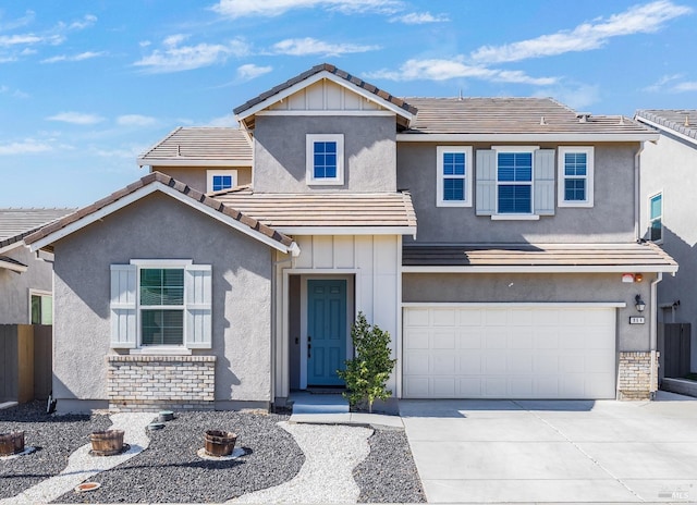 traditional home featuring board and batten siding, concrete driveway, a tiled roof, and stucco siding